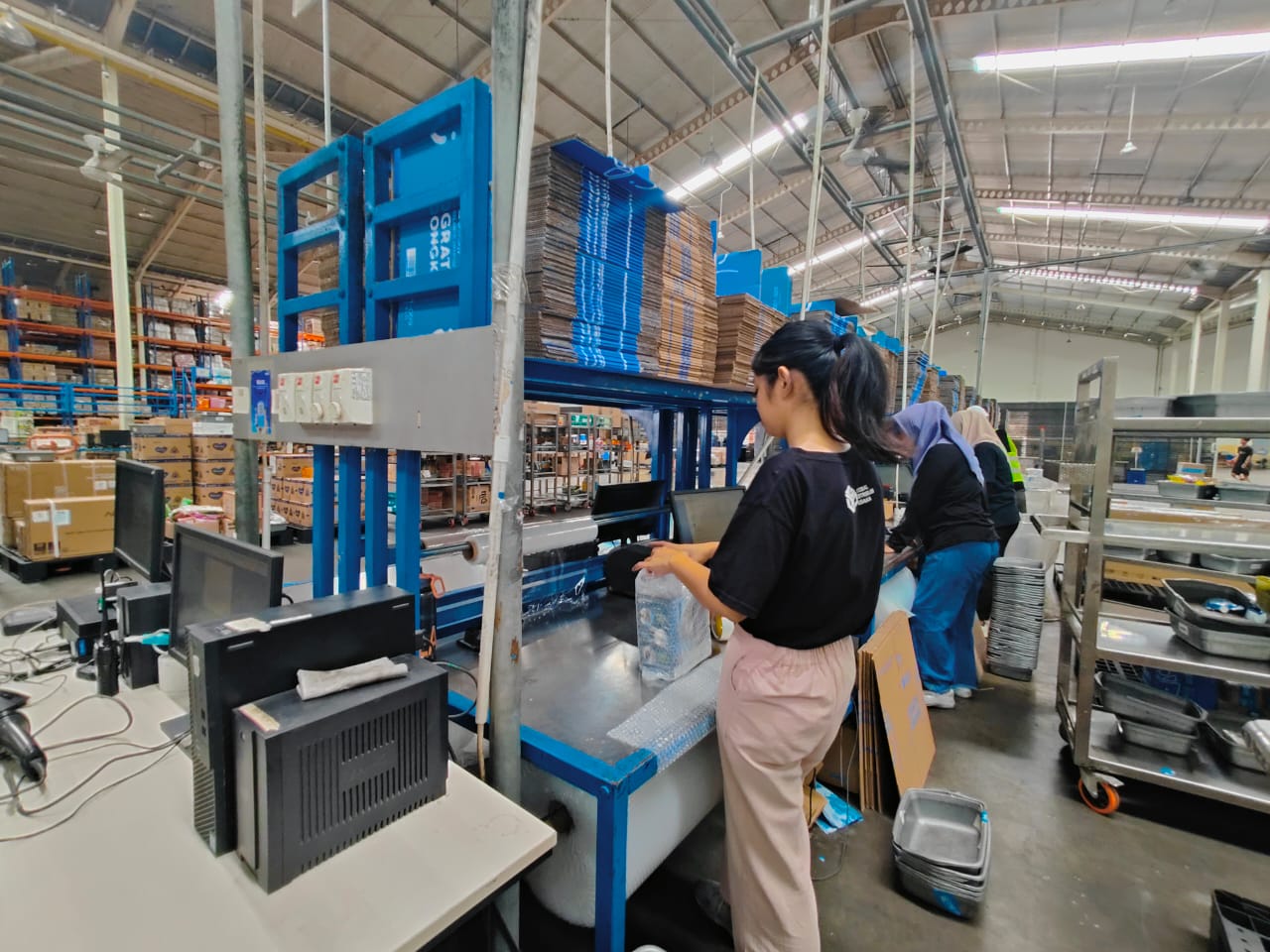 Pekerja melakukan packing barang di area gudang